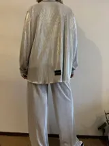Camisa de estilo plisado color plata, con botones y mangas largas, de corte holgado.