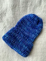 Gorro de lana merino azul con matices celestes y blancos, tejido a mano en punto elástico.