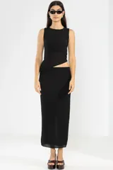 Falda midi negra de punto con abertura lateral y detalle de botón metálico con logo.