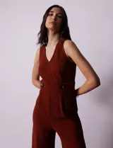 Mono enterito color ladrillo, marca June & Hudson, de crepe con escote en V, sin mangas, con detalle de botones en la cintura y cierre invisible en la espalda.