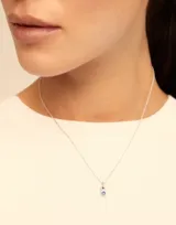 Charm redondo con cristal azul, elaborado artesanalmente en España con aleación de metales bañados en plata.