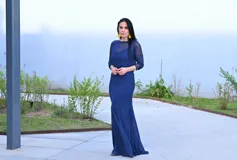 Vestido largo azul con corte sirena, escote redondo y mangas 3/4 de tul.