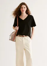 Blusa color negro de manga corta con cuello en V y corte oversized.