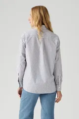 Camisa de manga larga a rayas verticales blancas, negras y violetas, con bolsillo en el pecho.