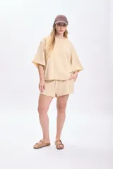 Short deportivo color amarillo, con cintura elástica y cordón ajustable. Diseño holgado con terminaciones desflecadas.