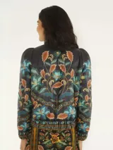 Campera puffer negra con estampado floral en tonos celeste, naranja y verde. Tiene cuello alto, cierre frontal y un bolsillo interno.