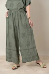 Pantalón palazzo verde oliva con estampado floral al tono, cintura elastizada y bolsillos laterales.
