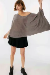 Blusa beige de tejido brillante, con cuello bote y mangas murciélago.