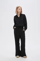 Pantalón ancho de viscosa color negro, con calce alto y bolsillos laterales.