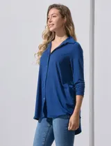 Camisola blanca de manga tres cuartos, marca Rio & Rian. Cuello con solapa y abertura central con botones. Manga con detalle fruncido.