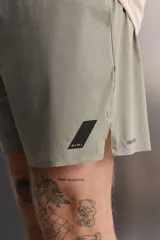 Shorts de entrenamiento color verde oliva, confeccionado en tejido técnico ligero y elástico con perforaciones. Tiene forro interior, cintura elástica ajustable con cordón, bolsillos laterales, bolsillo trasero con cierre de cremallera, bajo con aberturas laterales y logo estampado en la pierna.