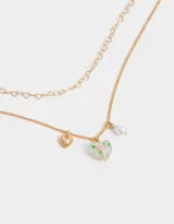 Collar corto doble con cadena dorada, una de eslabones y otra con dijes de corazones. Incluye dije de corazón, flor y perla.