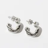 Par de aros tipo argolla gruesa de acero plateado con forma irregular.