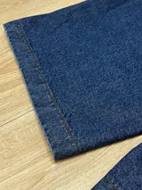 Bermuda de jean azul oscuro con lavado, corte muy ancho y largo hasta la mitad de la pantorrilla.