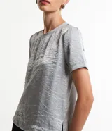 Blusa plateada de mangas cortas con cuello redondo pespuntado, botón en la espalda y superficie metalizada.