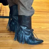 Botas de cuero negras de media caña con flecos y taco de 9 cm.