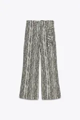 Pantalón de tiro alto con nudo delantero, de pernera ancha y estampado a rayas verticales en blanco y negro.