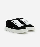 Championes negros de estilo skater con cordones gruesos blancos, suela blanca y detalles de líneas curvas blancas en los laterales.