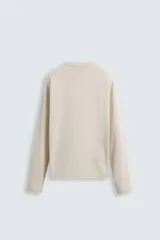 Camiseta color beige de corte relaxed fit, con cuello redondo y mangas largas combinadas con tejido de red.