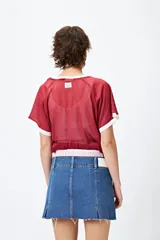 Minifalda de jean tiro bajo color negro con silueta evasé, dos tajos delanteros y ruedo desflecado.