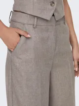 Pantalón de vestir color marrón claro, de tiro alto y corte recto.