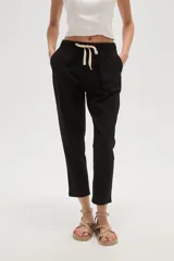 Pantalón negro de algodón, corte slim fit, tiro medio, con elástico en la cintura y cordón ajustable.