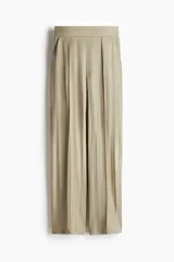 Pantalón de vestir color beige con pinzas, tiro alto, cintura elástica, bolsillos al bies y piernas amplias con raya adelante. Corte relajado.