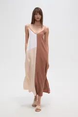 Vestido largo, holgado, con breteles finos y escote en V. Presenta un diseño de bloques de color en tonos blanco, beige claro y marrón.