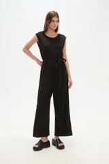 Mono negro de poliéster y lurex, corte recto, con cuello redondo y cinturón de lazo.