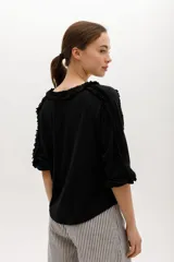 Blusa color beige de manga 3/4 confeccionada en algodón suave, con escote a la base y detalles de volados en 3D que recorren el frente, mangas y escote.