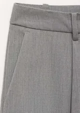 Pantalón de vestir gris con trabillas, tiro medio, bolsillos laterales, cierre oculto de botón, gancho y cremallera, diseño recto, pinzas, diseño largo y bolsillo de ribete en la parte posterior.