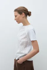 Remera blanca de manga corta con cuello redondo y frente de broderie calado.