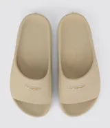 Ojotas Rider modelo Slide Drip, color beige, con textura en la plantilla y logo de la marca en la tira.