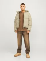Campera puffer color beige con capucha ajustable, cierre de cremallera, bolsillos frontales y puños acanalados.