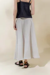 Falda midi de lino color gris claro, de silueta amplia y pretina elastizada color beige.