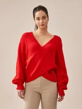Buzo de tejido de punto rojo, con escote en V cruzado tipo wrap y mangas largas abullonadas con puños ajustados.