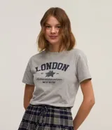 Remera gris melange de algodón y poliéster, con cuello redondo y mangas cortas. Estampa frontal con la palabra "London" en azul marino, una estrella y la frase "Big things starts from small places. Part of the story".