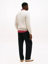 Buzo de cuello redondo color gris claro, con logo de Tommy Hilfiger bordado en el pecho y logo pequeño en la manga.