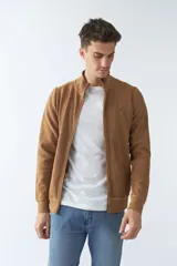 Campera marrón de algodón con cierre frontal, cuello alto, bolsillos laterales, puños y logo bordado en el pecho.