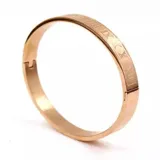 Brazalete rígido de acero color oro rosa con números romanos grabados.