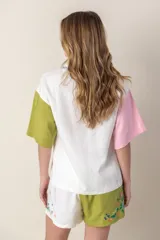 Camisa de mangas cortas con diseño color block en verde, blanco y rosa. Tiene un bolsillo con bordado de ave y flores bordadas en el frente.