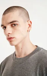 Remera gris melange de corte crop y calce oversize, con hombros caídos y cuello redondo.