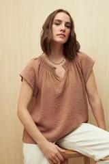 Blusa color ladrillo con escote en V y mangas cortas.