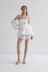 Blusa blanca strapless con mangas largas abullonadas.