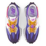 Championes New Balance modelo 327 de mujer, con capellada multicolor en tonos violeta, rojo, blanco y gris. Presentan cordones amarillos y suela de goma negra con detalles en amarillo.