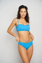 Top de bikini con escote corazón y estampado floral en tonos rosa, naranja, amarillo y blanco. Tiene breteles finos regulables y contorno inferior en color celeste.