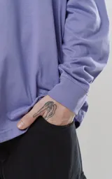 Remera manga larga lila con cuello redondo y puños de ribb al tono, calce regular.