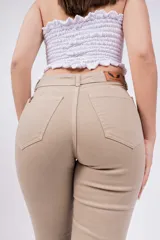Pantalón acampanado color beige, de tiro alto y corte ajustado en la cadera.