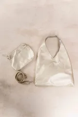 Bolso hobo reversible color azul marino, con textura símil cuero y correa bandolera extraíble.