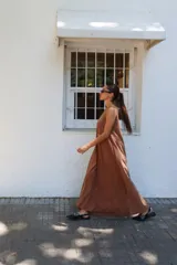 Vestido largo gris sin mangas, con escote redondo, bolsillos laterales y logo bordado en el frente.